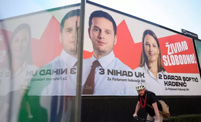 A man rides a bicycle beneath an election poster featuring Our Party (NS) candidates for the upcoming general elections in Sarajevo, Bosnia, on Sept. 29, 2026. (AP Photo/Armin Durgut)
