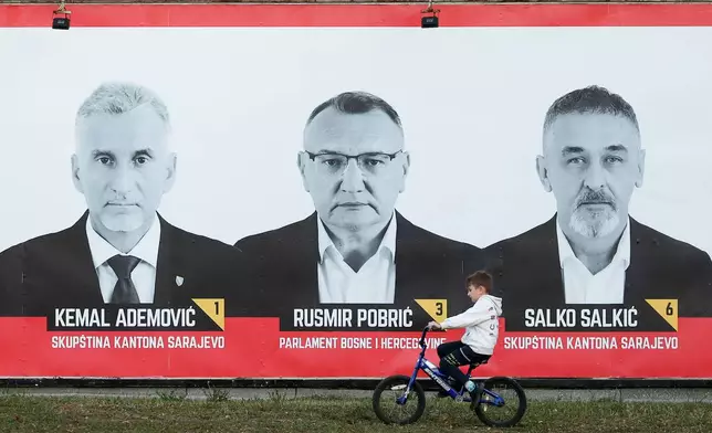 A boy rides a bicycle past an election poster featuring Red Lines (CL) candidates in the upcoming general elections in Sarajevo, Bosnia, on Sept. 30, 2026. (AP Photo/Armin Durgut)