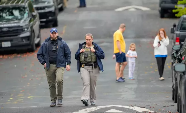 Homeland Security officers walk down 26th Street NE in Washington, early Monday, Oct. 12, 2026, during an investigation at the residence of Rep. Ilhan Omar, D-Minn. (AP Photo/J. Scott Applewhite)