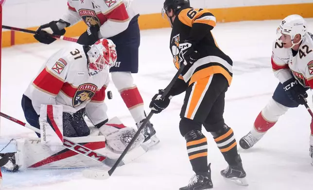 Pittsburgh Penguins' Rickard Rakell, center, has his shot blocked by Florida Panthers goalie Cooper Black (31) during the first period of an NHL hockey game in Pittsburgh, Thursday, Oct. 22, 2026. (AP Photo/Gene J. Puskar)