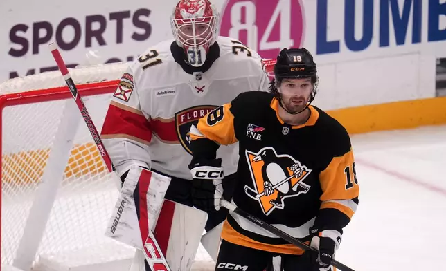 Pittsburgh Penguins' Tommy Novak (18) attempts to screen Florida Panthers goalie Cooper Black (31) during the first period of an NHL hockey game in Pittsburgh, Thursday, Oct. 22, 2026. (AP Photo/Gene J. Puskar)