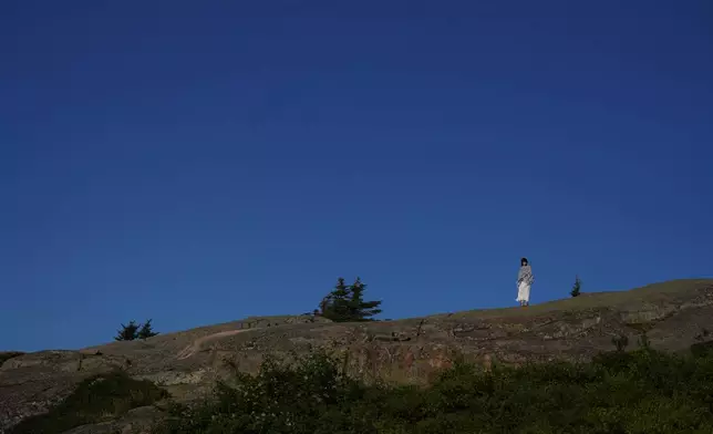Lindsey Acker of Ohio stands at the summit of Cadillac Mountain in Acadia National Park in Maine, on Saturday, July 11, 2026. (AP Photo/Jessie Wardarski)