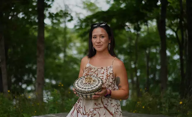 Lydia Soctomah sits for a portrait with a handcrafted fancy basket made from ash bark and sweetgrass at the College of the Atlantic in Bar Harbor, Maine, on Saturday, July 11, 2026. (AP Photo/Jessie Wardarski)