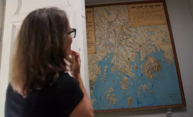 Abbe Museum Executive Director Betsy Richards, citizen of the Cherokee Nation, looks at an outdated map of Mount Desert Island in Maine, home to Acadia National Park, hanging in a small private museum location being renovated within the park, on Tuesday, July 1, 2026. (AP Photo/Jessie Wardarski)