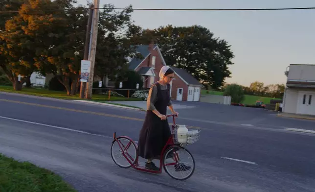 A woman from the Plain community rides a scooter in Intercourse, Pa., on Thursday, Oct. 8, 2026. (AP Photo/Jessie Wardarski)