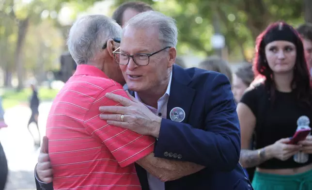 Democratic candidate for U.S. Senate Adam Hamilton hugs a supporter of his campaign for the U.S. Senate against Sen. Roger Marshall, R-Kan., after speaking at Washburn University, Wednesday, Oct. 28, 2026, in Topeka, Kan. (AP Photo/John Hanna)