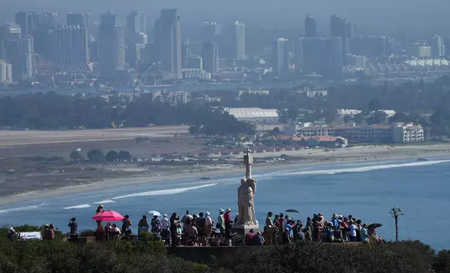 Spectators gather to view the USS Abraham Lincoln aircraft carrier as it returns to the San Diego Bay after deployment Thursday, Oct. 8, 2026, in San Diego. (AP Photo/Jae C. Hong)