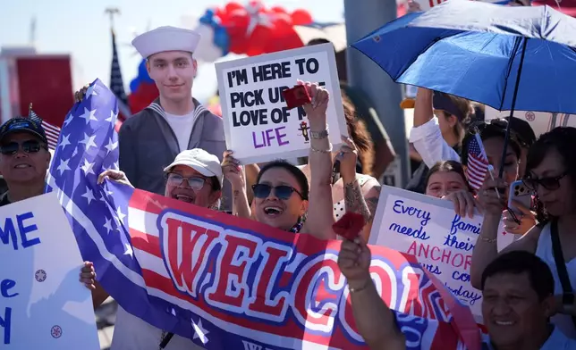 Family and friends wait to greet the USS Abraham Lincoln aircraft carrier as it returns to Naval Air Station North Island after deployment Thursday, Oct. 8, 2026, in Coronado, Calif. (AP Photo/Gregory Bull)