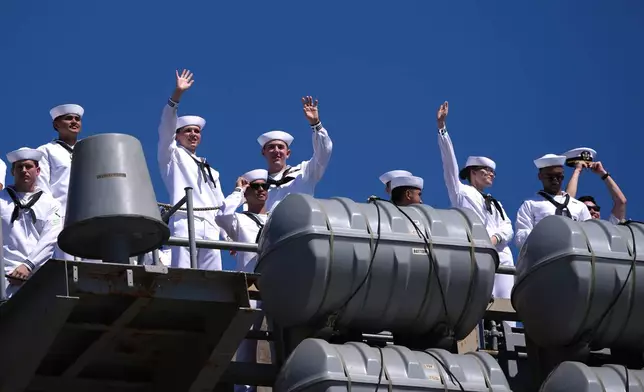 Sailors wave aboard the USS Abraham Lincoln aircraft carrier as it returns to Naval Air Station North Island after deployment Thursday, Oct. 8, 2026, in Coronado, Calif. (AP Photo/Gregory Bull)