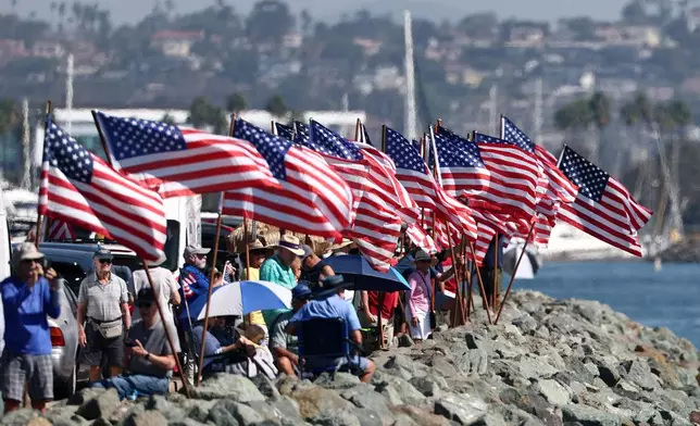 Spectators gather to view the USS Abraham Lincoln aircraft carrier as it returns to the San Diego Bay after deployment Thursday, Oct. 8, 2026, in San Diego. (AP Photo/Karl Anderson)