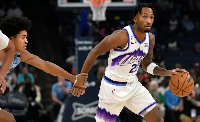 Utah Jazz guard Darryn Peterson (22) handles the ball ahead of Memphis Grizzlies forward Jaylen Wells in the first half of an NBA basketball game Wednesday, Oct. 21, 2026, in Memphis, Tenn. (AP Photo/Brandon Dill)