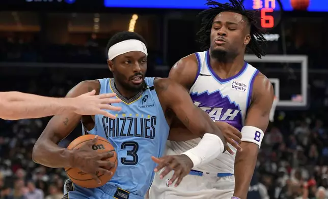 Memphis Grizzlies forward Jerami Grant (3) drives against Utah Jazz guard Isaiah Collier (8) in the second half of an NBA basketball game Wednesday, Oct. 21, 2026, in Memphis, Tenn. (AP Photo/Brandon Dill)