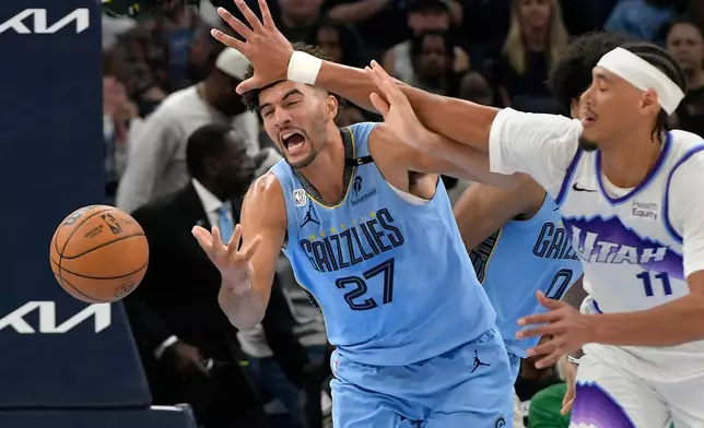 Memphis Grizzlies forward Cameron Boozer (27) and Utah Jazz center Jaxson Hayes (11) struggle for control of the ball in the second half of an NBA basketball game Wednesday, Oct. 21, 2026, in Memphis, Tenn. (AP Photo/Brandon Dill)