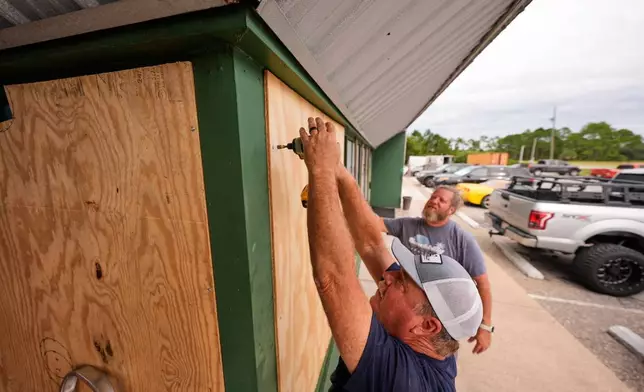 Mike Howard, foreground, and Joshua Brown board up Perdido Key Sports Bar as Hurricane Isaias approaches Perdido Key, Fla., Thursday, Oct. 8, 2026. (AP Photo/Gerald Herbert)