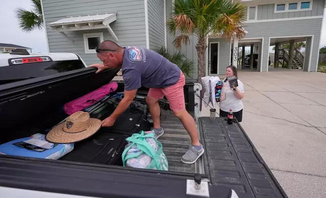 Daniel and Brand Harp, of Lebanon Tenn., here on vacation, pack their belongings to evacuate in the morning as Hurricane Isaias approaches Pensacola Beach, Fla., Thursday, Oct. 8, 2026. (AP Photo/Gerald Herbert)