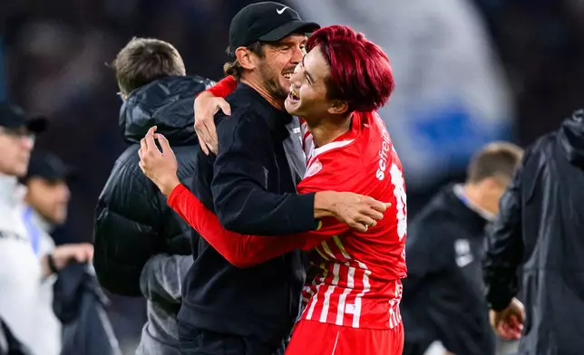 Freiburg's Keisuke Goto, right, celebrates with coach Julian Schuster after the German Bundesliga soccer match between Freiburg and FC Schalke 04 in Freiburg im Breisgau, Germany, Sunday, Oct. 11, 2026. (Tom Weller/dpa via AP)