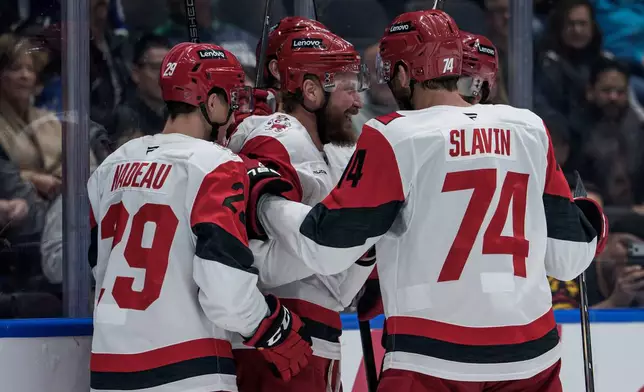 Carolina Hurricanes' Nicolas Deslauriers, center, celebrates his goal against the Vancouver Canucks with his teammates during the second period of an NHL hockey game in Vancouver, British Columbia, Tuesday, Oct. 20, 2026. (Ethan Cairns/The Canadian Press via AP)