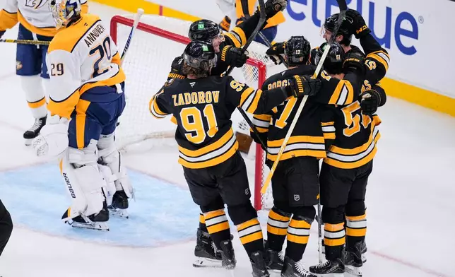 Boston Bruins, right, celebrate after a goal by Mark Kastelic, as Nashville Predators' Justus Annunen, left, skates away during the third period of an NHL hockey game, Thursday, Oct. 22, 2026, in Boston. (AP Photo/Charles Krupa)