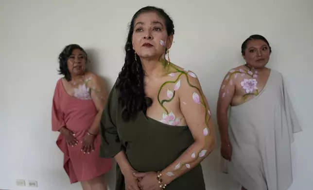 Breast cancer survivors whose mastectomy scars are covered with body paint receive instructions before a Breast Cancer Awareness Month event in Quito, Ecuador, Wednesday, Oct. 28, 2026. (AP Photo/Dolores Ochoa)