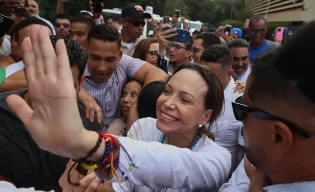 Venezuelan opposition leader Maria Corina Machador waves after visiting a nursing home in La Guaira, Venezuela, Wednesday, Oct. 28, 2026. (AP Photo/Pedro Mattey)