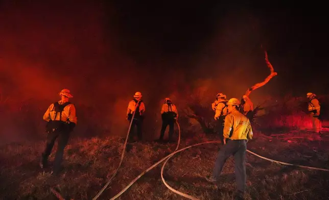 Crews make a stand in front of the Bryson Fire on Thursday, Oct. 15, 2026, in Malibu, Calif. (AP Photo/Jae C. Hong)