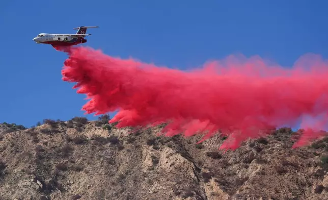 A tanker drops retardant on the Peak Fire Thursday, Oct. 15, 2026, in Azusa, Calif. (AP Photo/Jae C. Hong)