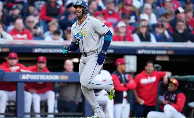 Tampa Bay Rays' Yandy Díaz scores on a walk against the Cleveland Guardians during the first inning in Game 5 of an American League Championship Series baseball game in Cleveland, Sunday, Oct. 18, 2026. (AP Photo/David J. Phillip)