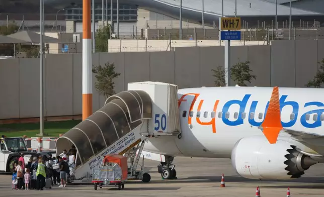 Passengers embark on a FlyDubai aircraft at Ben Gurion International Airport, near Tel Aviv, Israel, Wednesday, Sept. 30, 2026. (AP Photo/Ariel Schalit)