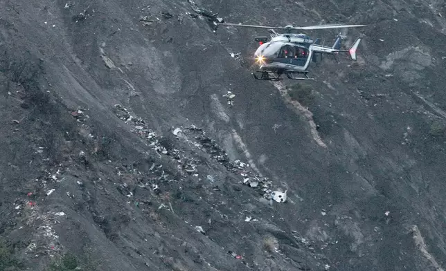 FILE - A rescue helicopter flies over debris of a Germanwings passenger jet, near Seyne-les-Alpes, Frances, March 24, 2015. (AP Photo/Claude Paris, File)
