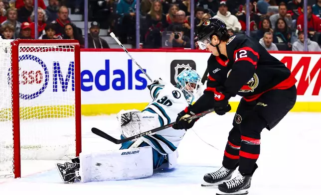 San Jose Sharks goaltender Yaroslav Askarov (30) makes a save against Ottawa Senators' Shane Pinto (12) during the second period of an NHL hockey game in Ottawa, Ontario, Thursday, Oct. 22, 2026. (Keito Newman/The Canadian Press via AP)