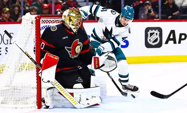 San Jose Sharks' Ivar Stenberg (41) looks to make a tip in front of Ottawa Senators goaltender Samuel Ersson, left, during the first period of an NHL hockey game in Ottawa, Ontario, Thursday, Oct. 22, 2026. (Keito Newman/The Canadian Press via AP)