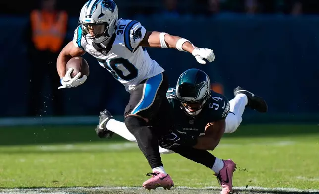 Carolina Panthers running back Chuba Hubbard, left, is tackled by Philadelphia Eagles linebacker Jeremiah Trotter Jr. during the second half of an NFL football game in Philadelphia, Sunday, Oct. 18, 2026. (AP Photo/Chris Szagola)