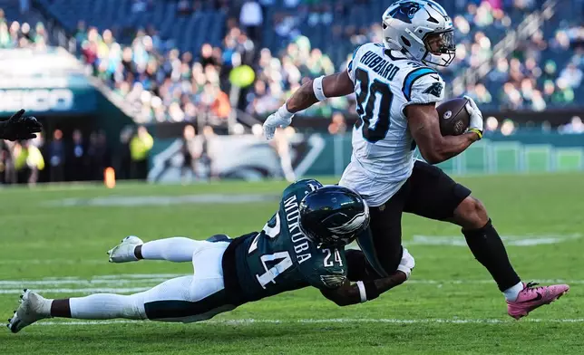 Carolina Panthers running back Chuba Hubbard is brought down by Philadelphia Eagles safety Andrew Mukuba, left, during the second half of an NFL football game in Philadelphia, Sunday, Oct. 18, 2026. (AP Photo/Matt Rourke)