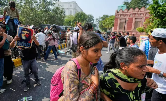 Protesters take cover as police arrives to detain them during a demonstration demanding the resignation of Chief Election Commissioner Gyanesh Kumar in New Delhi, India, Saturday, Oct. 10, 2026.(AP Photo/Manish Swarup)