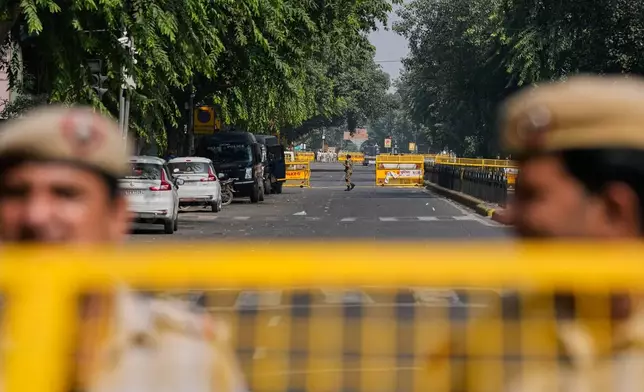 Delhi police officers stand guard at barricades blocking roads leading to the site of a protest by the Cockroach Janta Party demanding the resignation of Chief Election Commissioner Gyanesh Kumar in New Delhi, India, Saturday, Oct.10, 2026. (AP Photo/Manish Swarup)