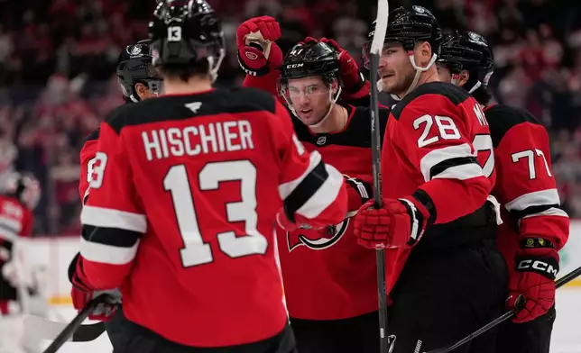 New Jersey Devils' Declan Chisholm, center, celebrates his goal with teammates during the second period of an NHL hockey game against the Colorado Avalanche in Newark, N.J., Tuesday, Oct. 20, 2026. (AP Photo/Seth Wenig)