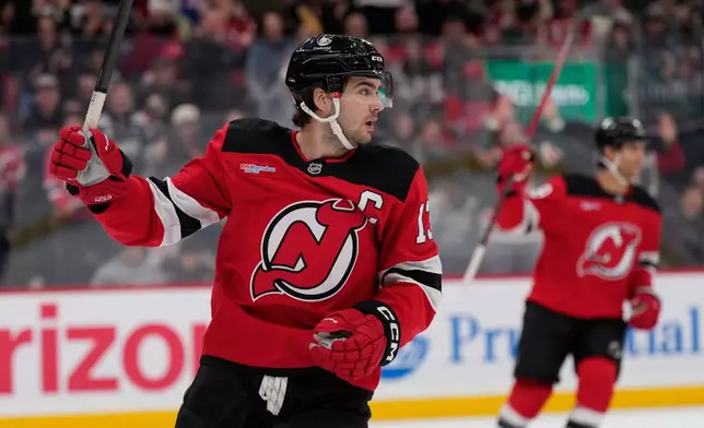New Jersey Devils' Nico Hischier celebrates a goal by teammate Declan Chisholm during the second period of an NHL hockey game against the Colorado Avalanche in Newark, N.J., Tuesday, Oct. 20, 2026. (AP Photo/Seth Wenig)