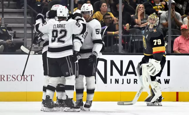 The Los Angeles Kings, left, celebrate after a goal against Vegas Golden Knights goaltender Carter Hart (79) during the second period of an NHL hockey game Saturday, Oct. 10, 2026, in Las Vegas. (AP Photo/David Becker)