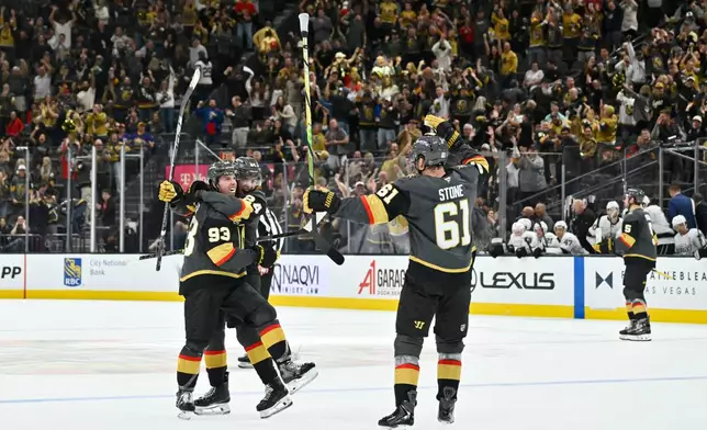 Vegas Golden Knights right wing Mitch Marner (93), left wing Trevor Connelly (24) and right wing Mark Stone (61) celebrate Marner's overtime goal against the Los Angeles Kings in an NHL hockey game Saturday, Oct. 10, 2026, in Las Vegas. (AP Photo/David Becker)