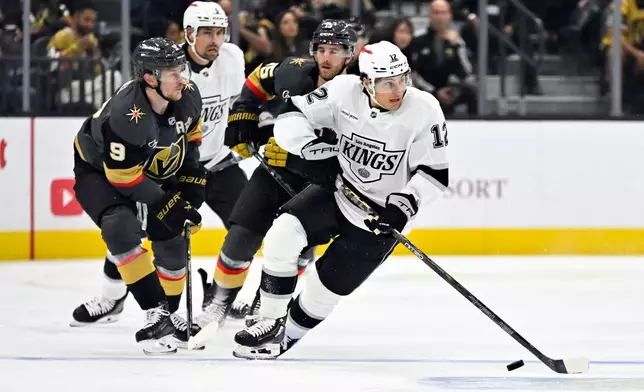 Los Angeles Kings left wing Trevor Moore (12) handles the puck against the Vegas Golden Knights during the first period of an NHL hockey game Saturday, Oct. 10, 2026, in Las Vegas. (AP Photo/David Becker)