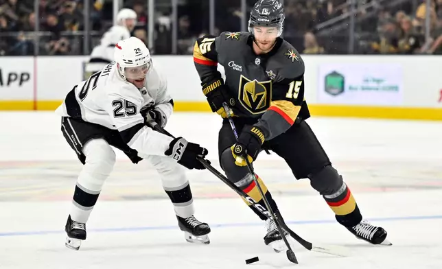 Los Angeles Kings right wing Jared Wright (25) and Vegas Golden Knights defenseman Noah Hanifin (15) battle for the puck during the first period of an NHL hockey game Saturday, Oct. 10, 2026, in Las Vegas. (AP Photo/David Becker)