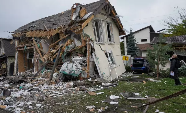 A woman looks at residential house destroyed in a Russian missile strike in Kyiv, Thursday, Oct. 22, 2026. (AP Photo/Efrem Lukatsky)