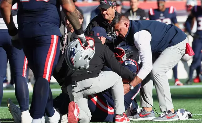 New England Patriots head coach Mike Vrabel, right, helps center Ben Brown, center, up from the field during the second half of an NFL football game against the New York Jets in Foxborough, Mass., Sunday, Oct. 18, 2026. (AP Photo/Mark Stockwell)