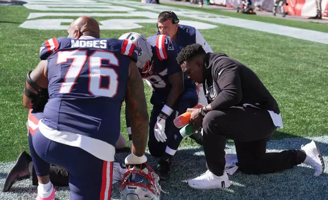 New England Patriots wide receiver Romeo Doubs, center, on ground, is tended to after a possible injury during the first half of an NFL football game against the New York Jets in Foxborough, Mass., Sunday, Oct. 18, 2026. (AP Photo/Charles Krupa)