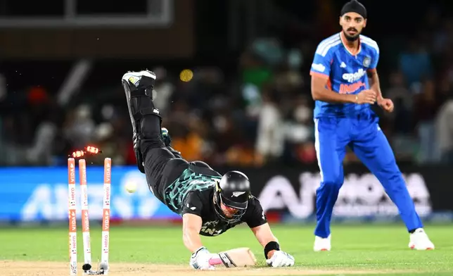 New Zealand's Glenn Phillips dives for the crease as India's Arshdeep Singh, right, watches on during the second T20 cricket international between New Zealand and India in Christchurch, New Zealand, Saturday, Oct. 24, 2026. (Chris Symes/Photosport via AP)