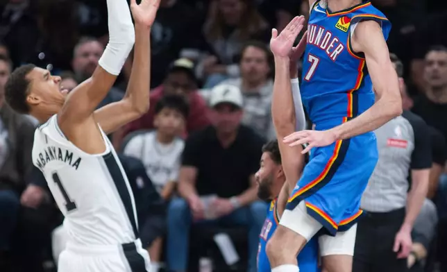 Oklahoma City Thunder center Chet Holmgren (7) attempts to block a shot by San Antonio Spurs center Victor Wembanyama (1) during the first half of an NBA basketball game, Tuesday, Oct. 20, 2026, in San Antonio. (AP Photo/Darren Abate)