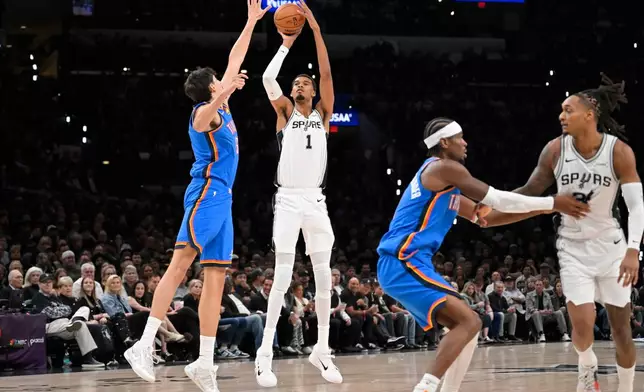 San Antonio Spurs center Victor Wembanyama (1) shoots against Oklahoma City Thunder center Aday Mara during the first half of an NBA basketball game, Tuesday, Oct. 20, 2026, in San Antonio. (AP Photo/Darren Abate)