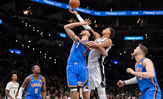San Antonio Spurs center Victor Wembanyama shoots against Oklahoma City Thunder center Chet Holmgren (7) during the first half of an NBA basketball game, Tuesday, Oct. 20, 2026, in San Antonio. (AP Photo/Darren Abate)