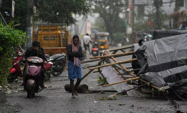 A man walks past the destruction caused at Kakinada, India, after Cyclone Arnab crossed the Andhra Pradesh coast in the early hours of Wednesday, Oct. 28, 2026. (AP Photo/Mahesh Kumar A.)