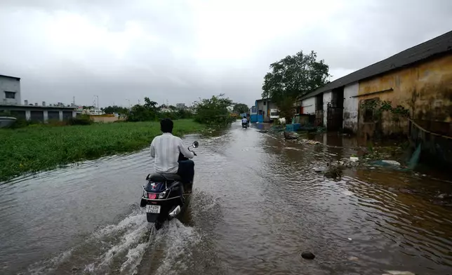 Motorists navigate floodwaters at Kakinada, India, as Cyclone Arnab crossed the Andhra Pradesh coast in the early hours of Wednesday, Oct. 28, 2026. (AP Photo/Mahesh Kumar A.)